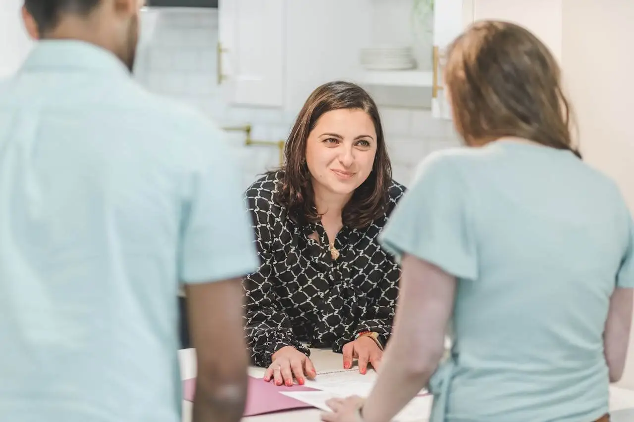 female-manager-talking-to-two-nurses HR Director discussing performance with healthcare staff
