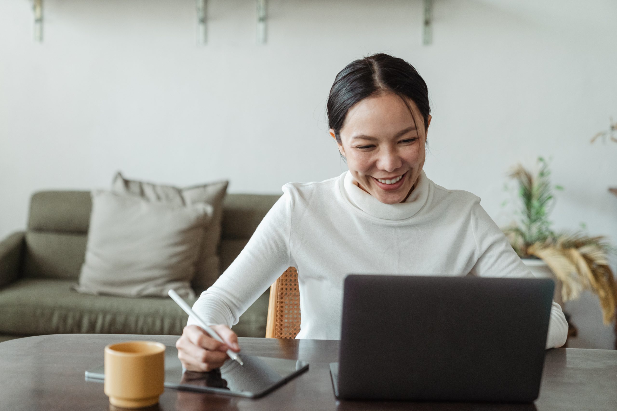 woman-working-at-home-and-making-video-call-on-laptop Woman doing performance reviews on laptop video call from home