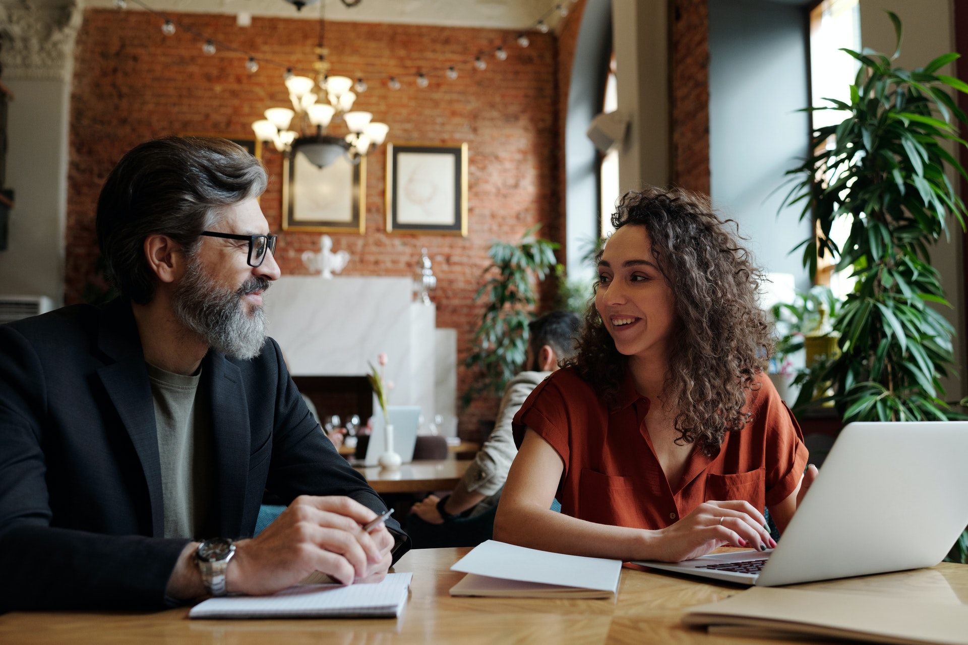 man-woman-sitting-at-desk Manager and employee discuss the performance management process