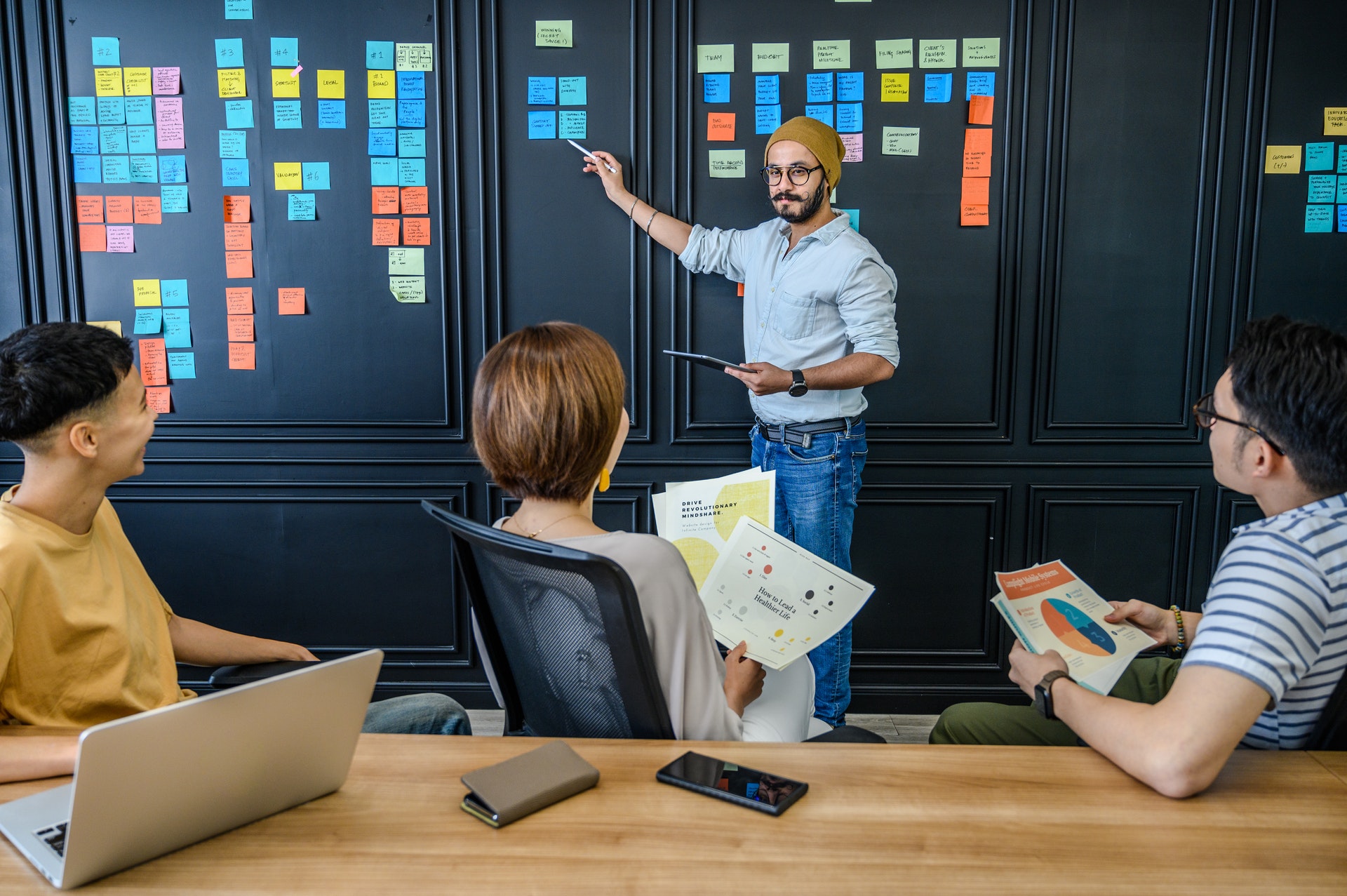 manager-employees-meeting Manager discussing OKR examples with three employees