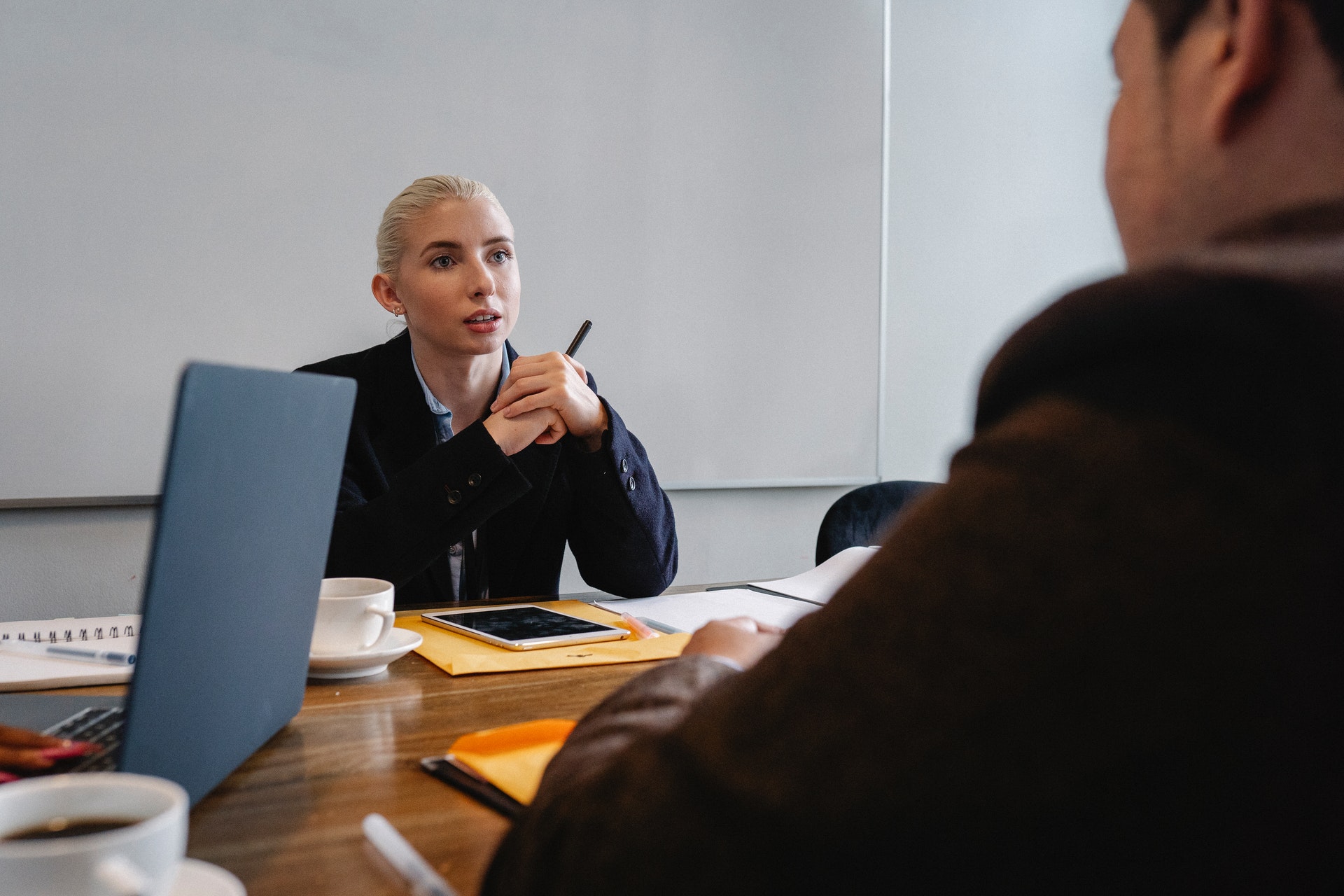 woman-at-desk-in-meeting Woman manager discussing performance review phrases win meeting