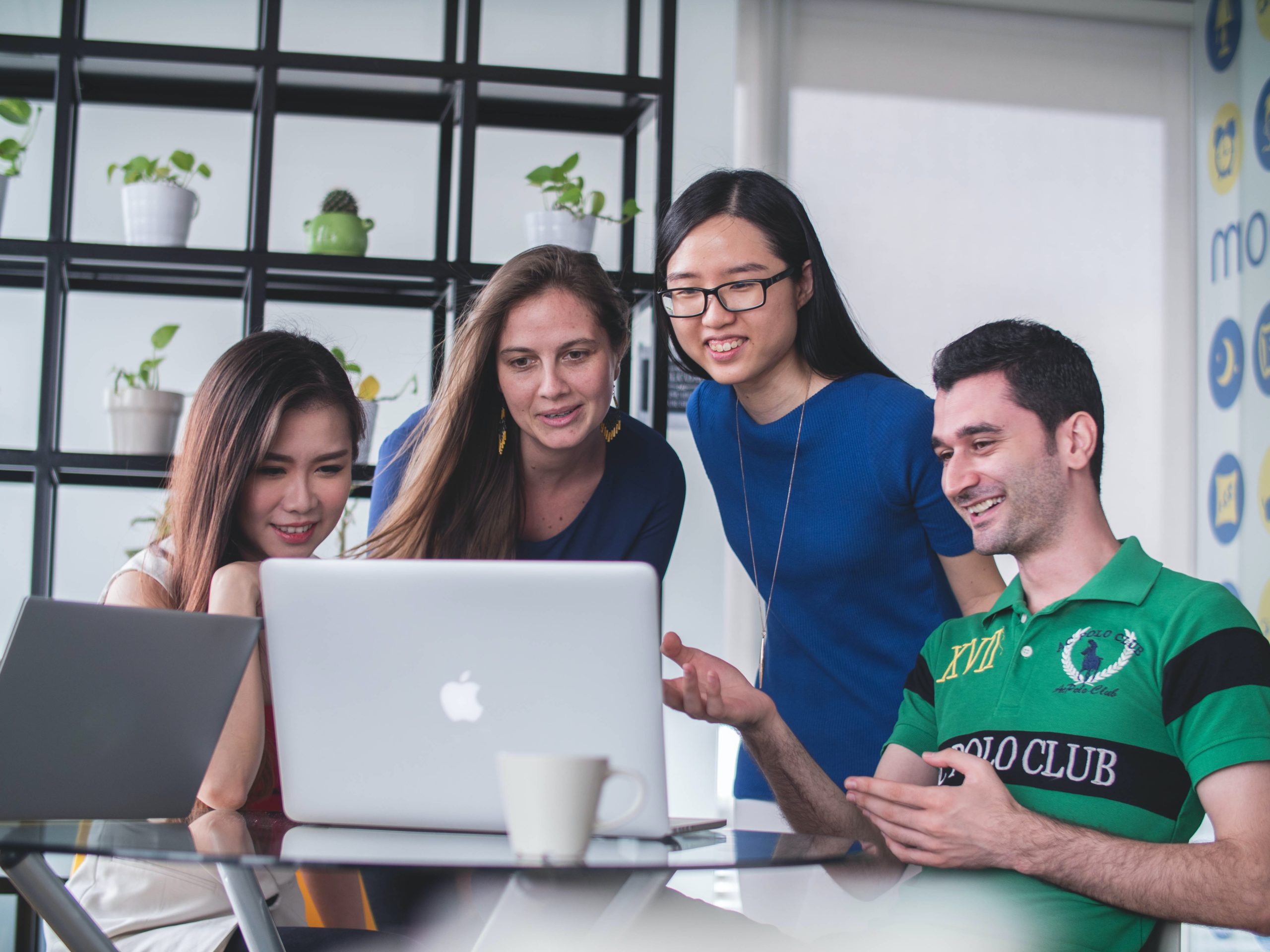 four-people-around-laptop Happy HR team grouped around computer