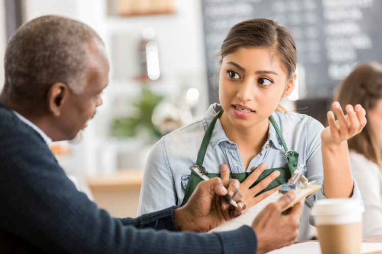 man-woman-speaking Employee and manager discussing performance evaluation