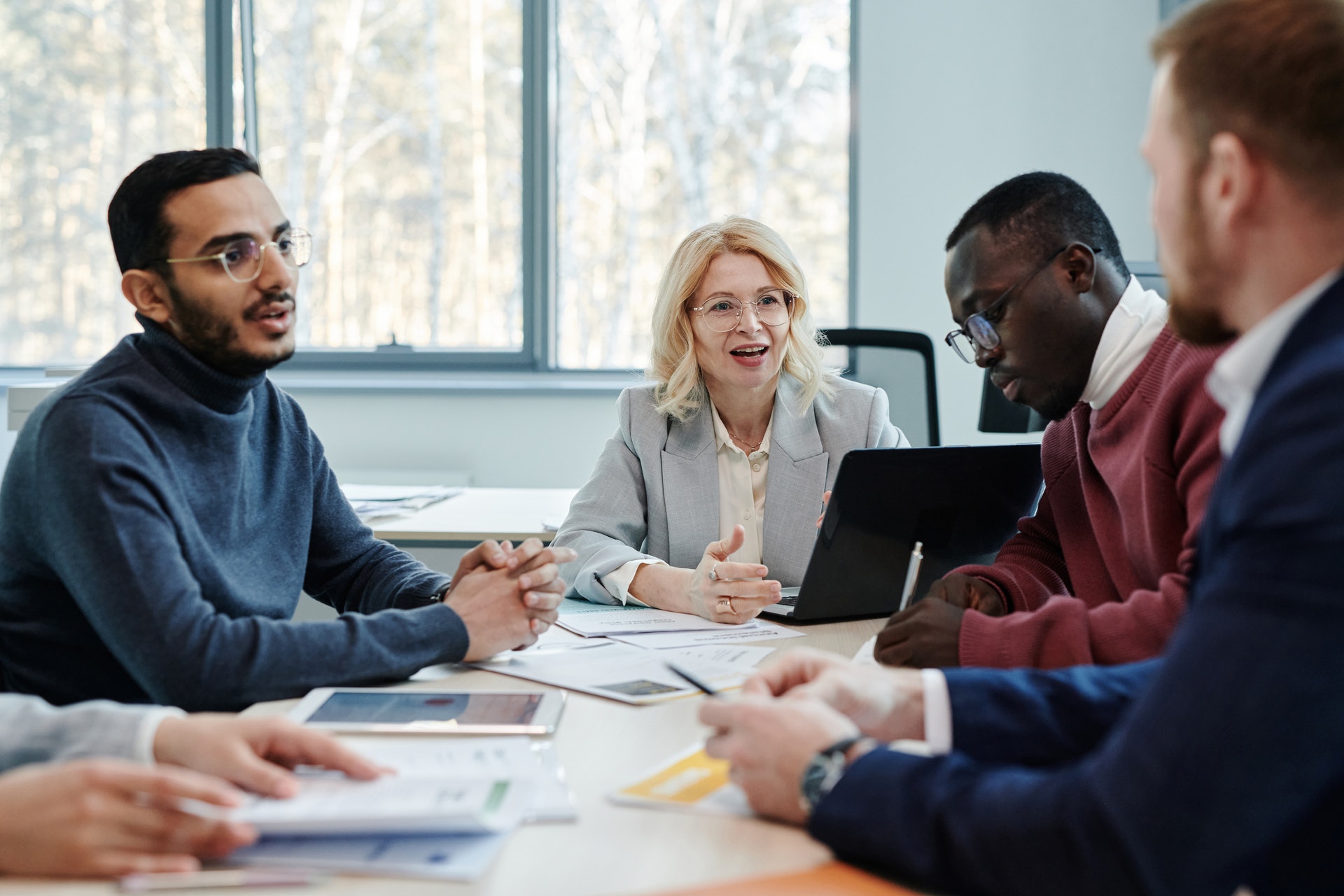 Group-of-people-at-desk-meeting Employee meeting to discuss quarterly performance review