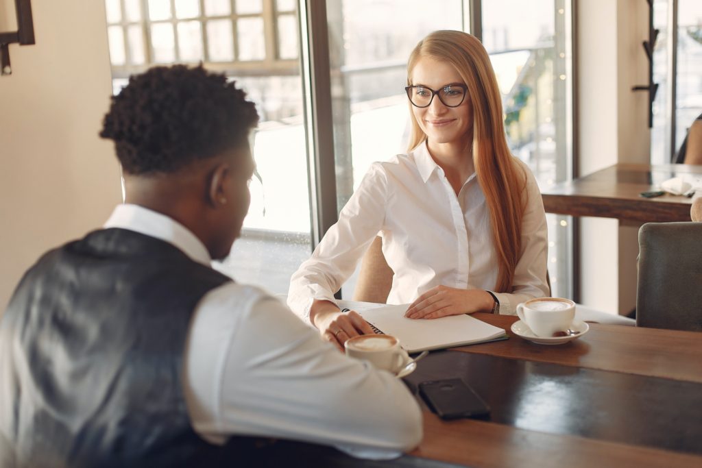 Black man and smiling woman discussing exit interviews