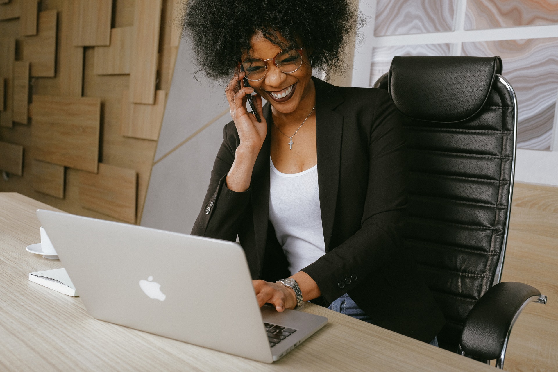 smiling-woman-desk-macbook Professional Black woman during online team communication