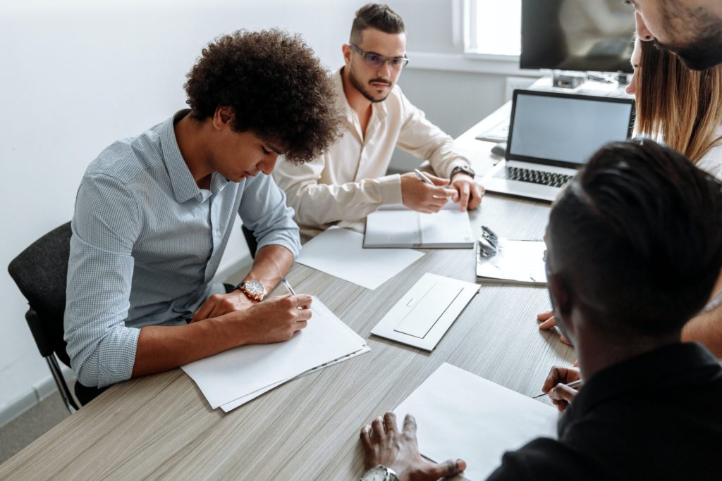 4 colleagues working on team performance at desk