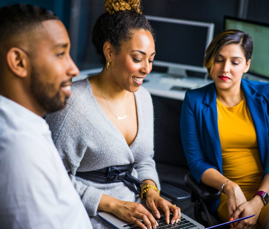 Three diverse colleagues looking at performance rating scale on laptop