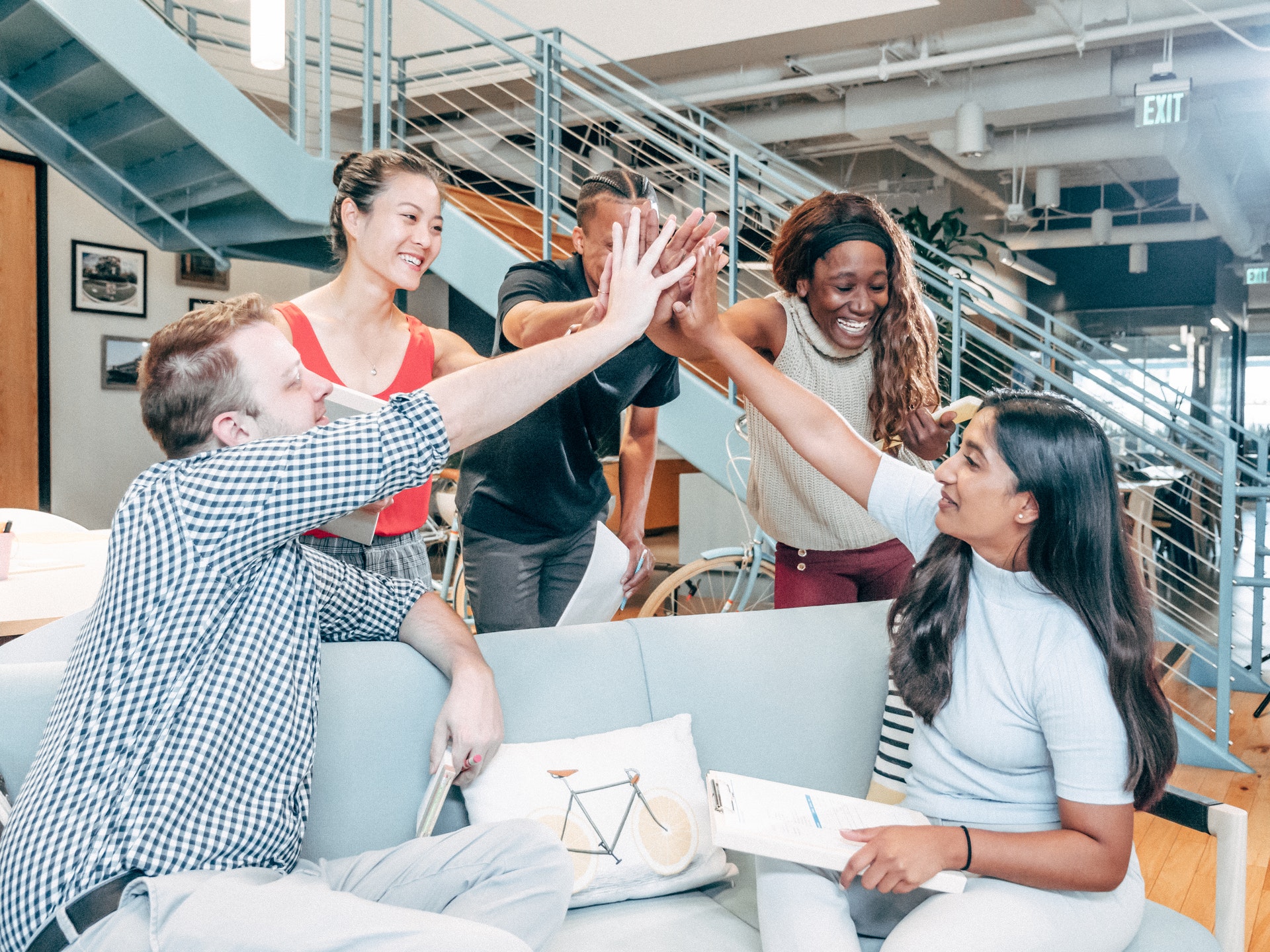 five-people-high-five Diverse group of men and women high-fiving about organizational success