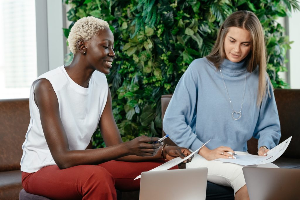 Two women colleagues, seated reviewing offboarding documents