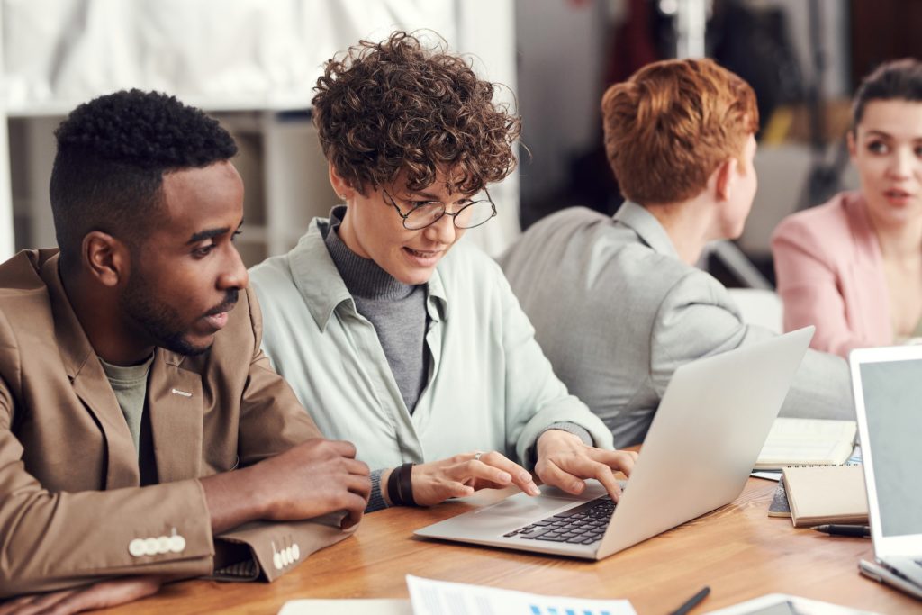 Inclusive group of colleagues reading about PTO on laptop