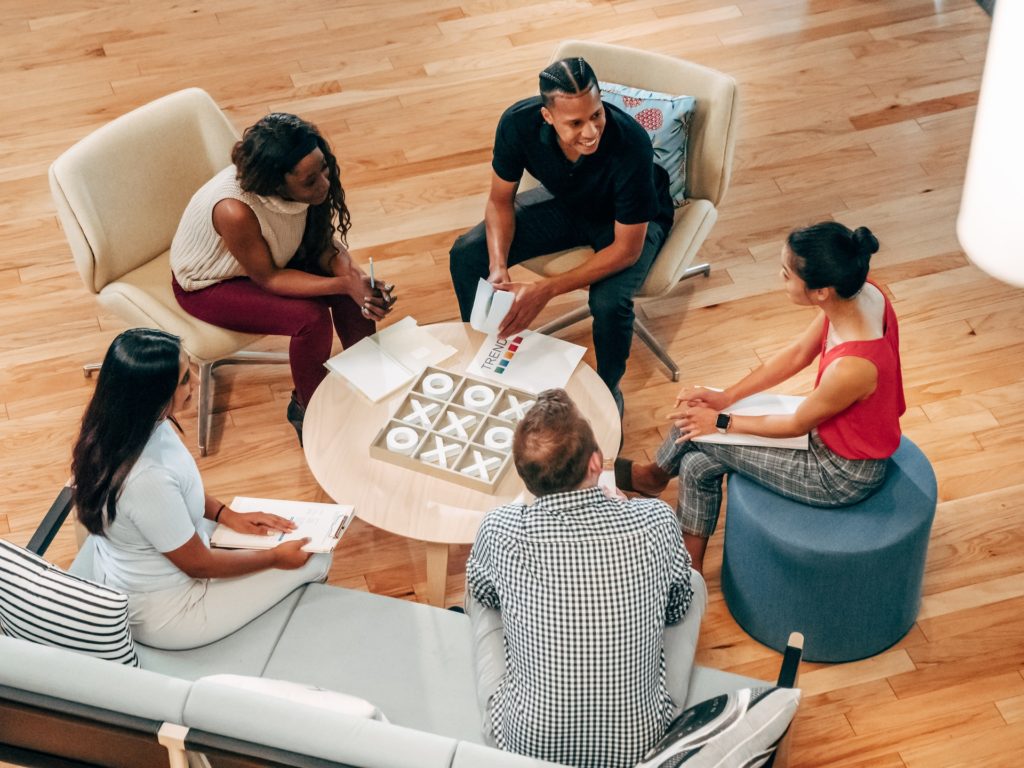 Group of five coworkers sitting discussing employment equity