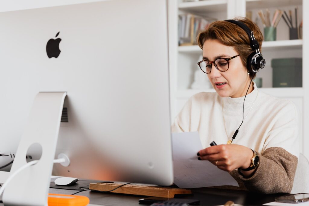 Woman with headset and desktop computer discussing layoffs