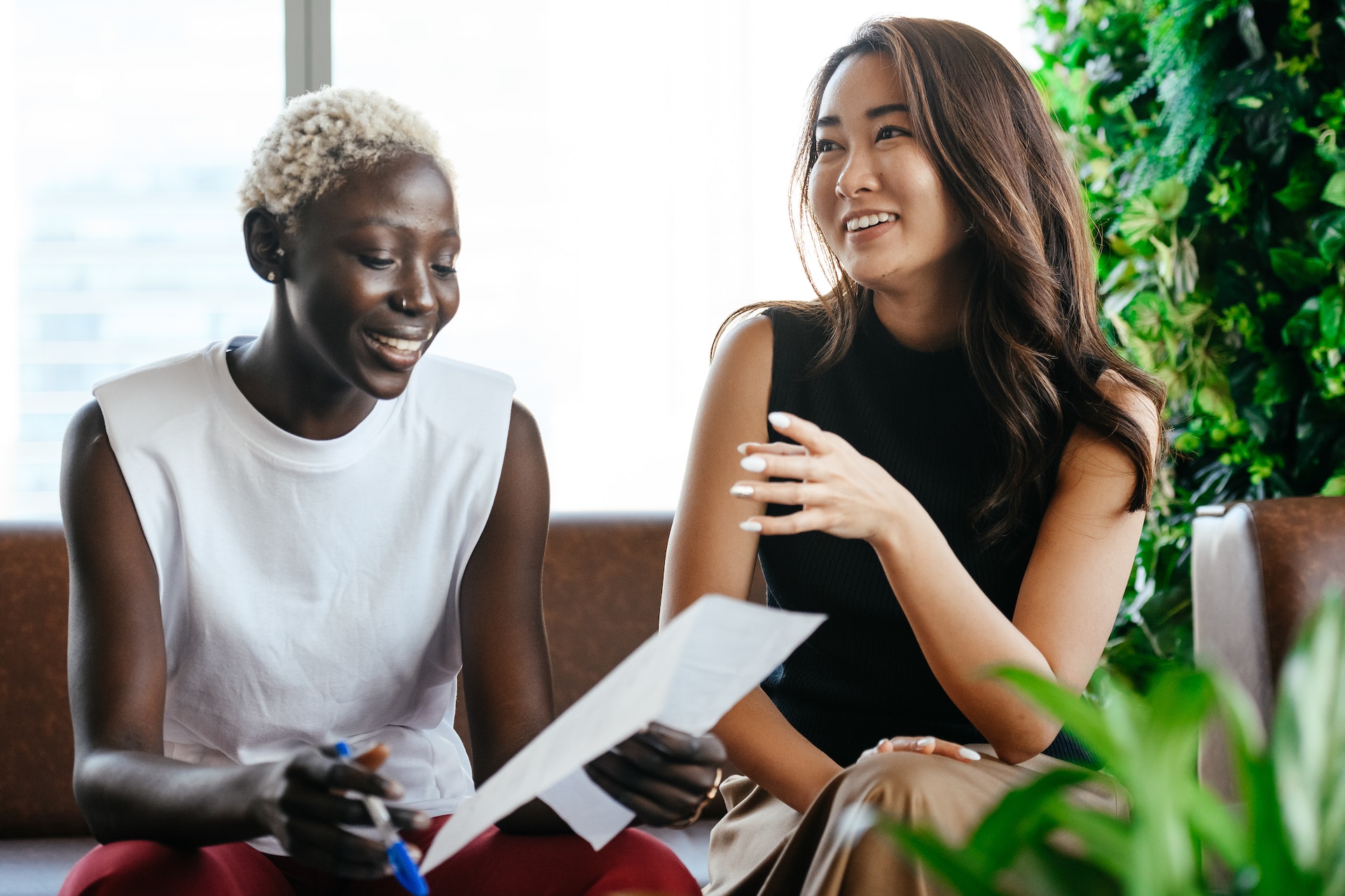 black-woman-asian-woman-happy-document Two women colleagues happily doing an employee assessment