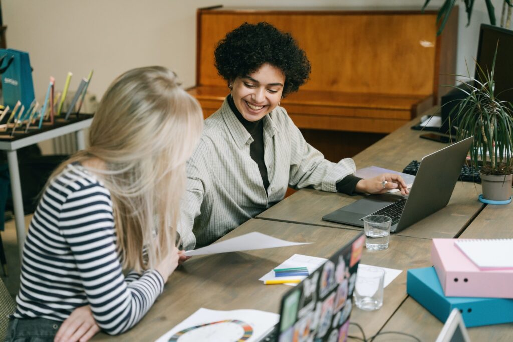 Two women colleagues sharing workplace feedback with one another