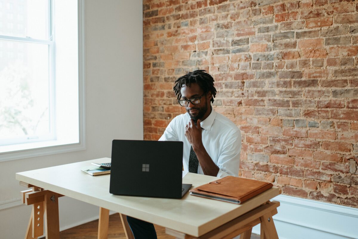 black-man-desk-laptop Black man using laptop to learn about manager effectiveness