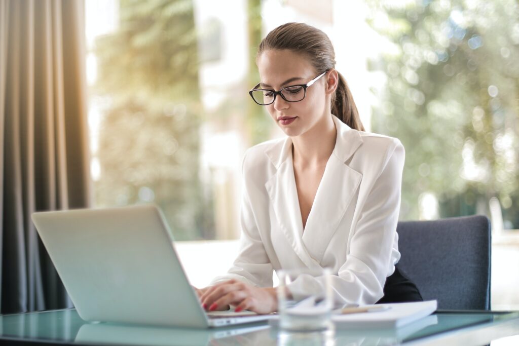 Woman in an office setting doing leadership assessment on a laptop