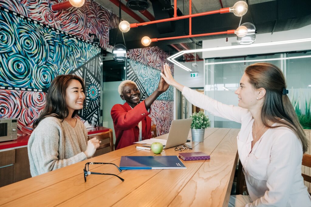 Three diverse women happily meeting after employee listening meeting