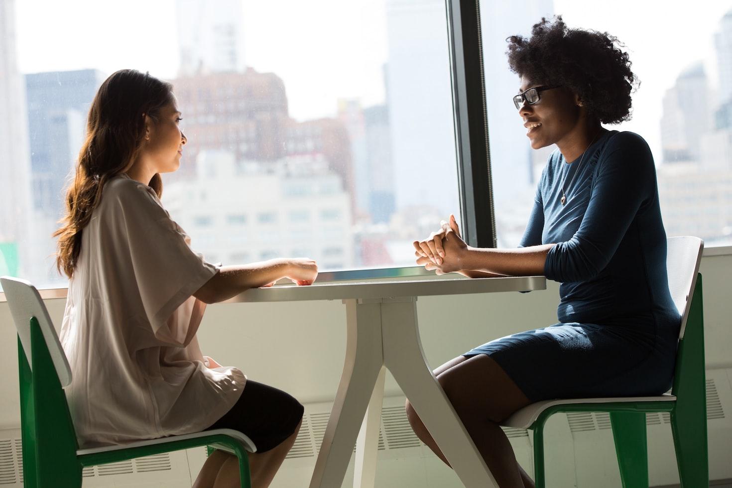 women-table-sitting Two women sitting discussing management tips