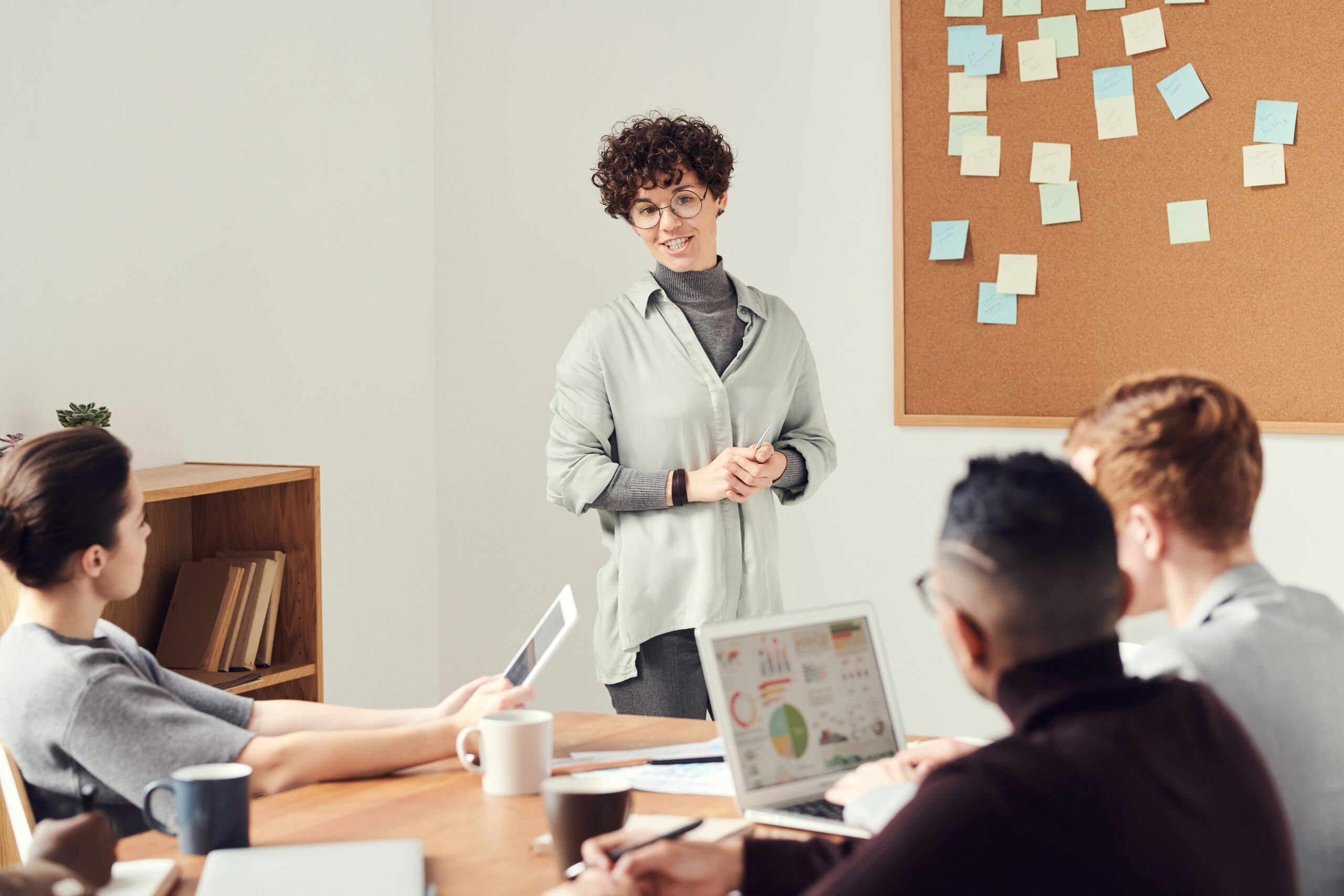woman-wearing-gray-cardigan-and-eyeglasses Manager discussing with employees of ways to increase employee well-being
