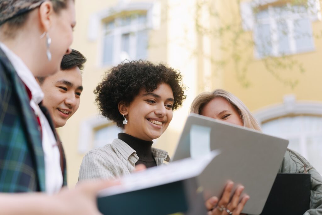 Smiling employees looking at a work document together.
