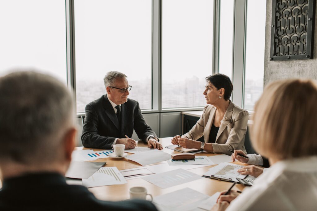 An elderly man and woman are having a discussion in a business meeting