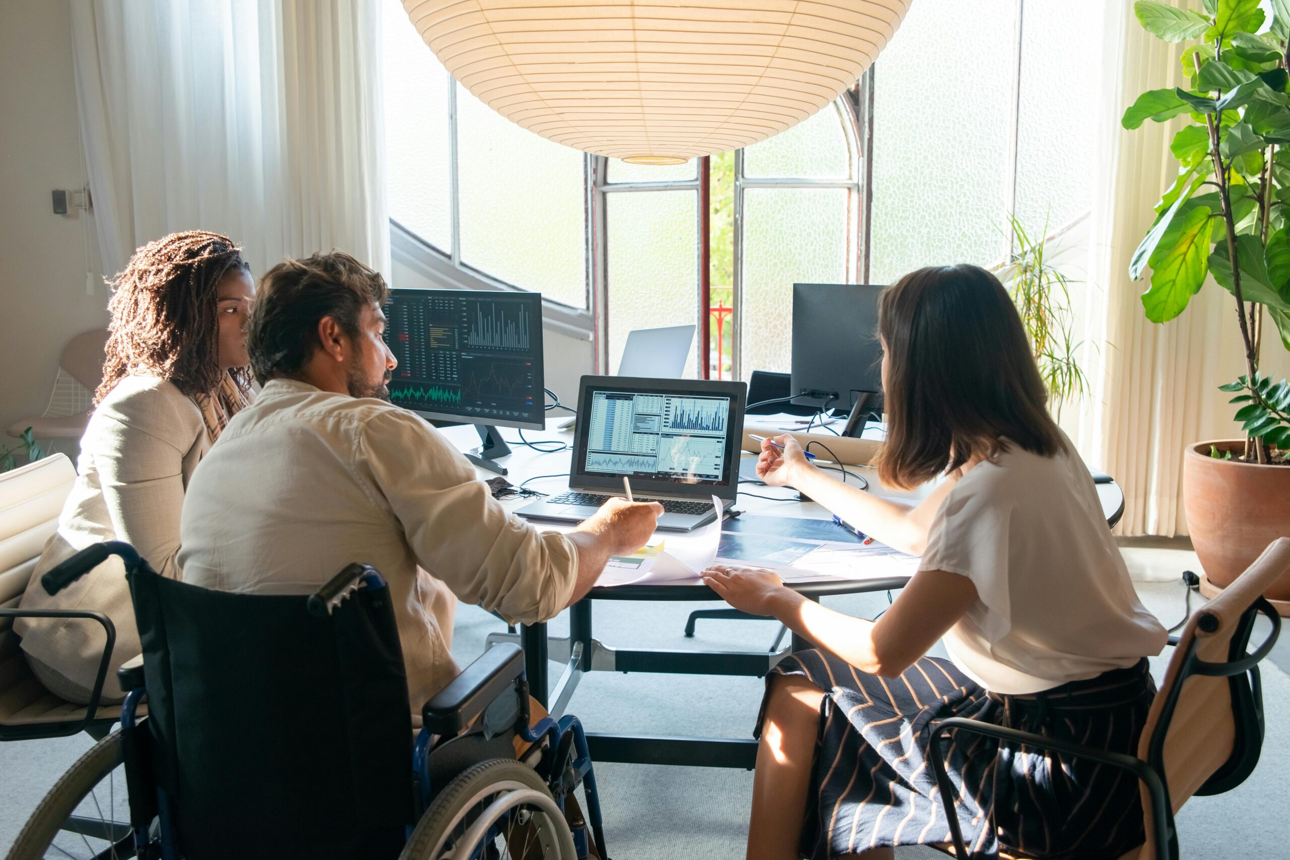 photograph-of-colleagues-talking-near-a-laptop-with-charts HR professionals discussing employee engagement and motivation