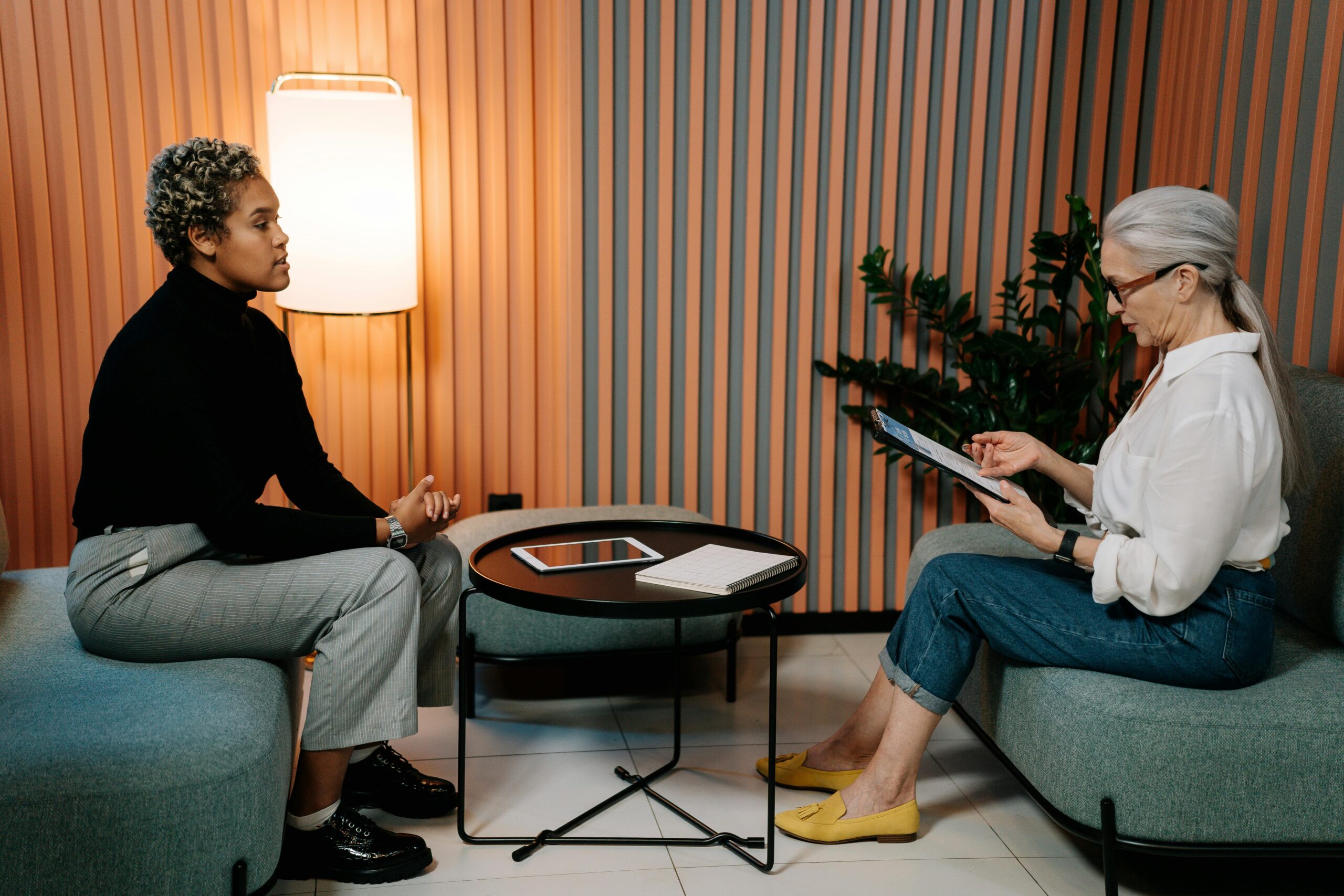woman-in-black-shirt-and-blue-denim-jeans-sitting-on-chair An employee is receiving a performance review from her boss.