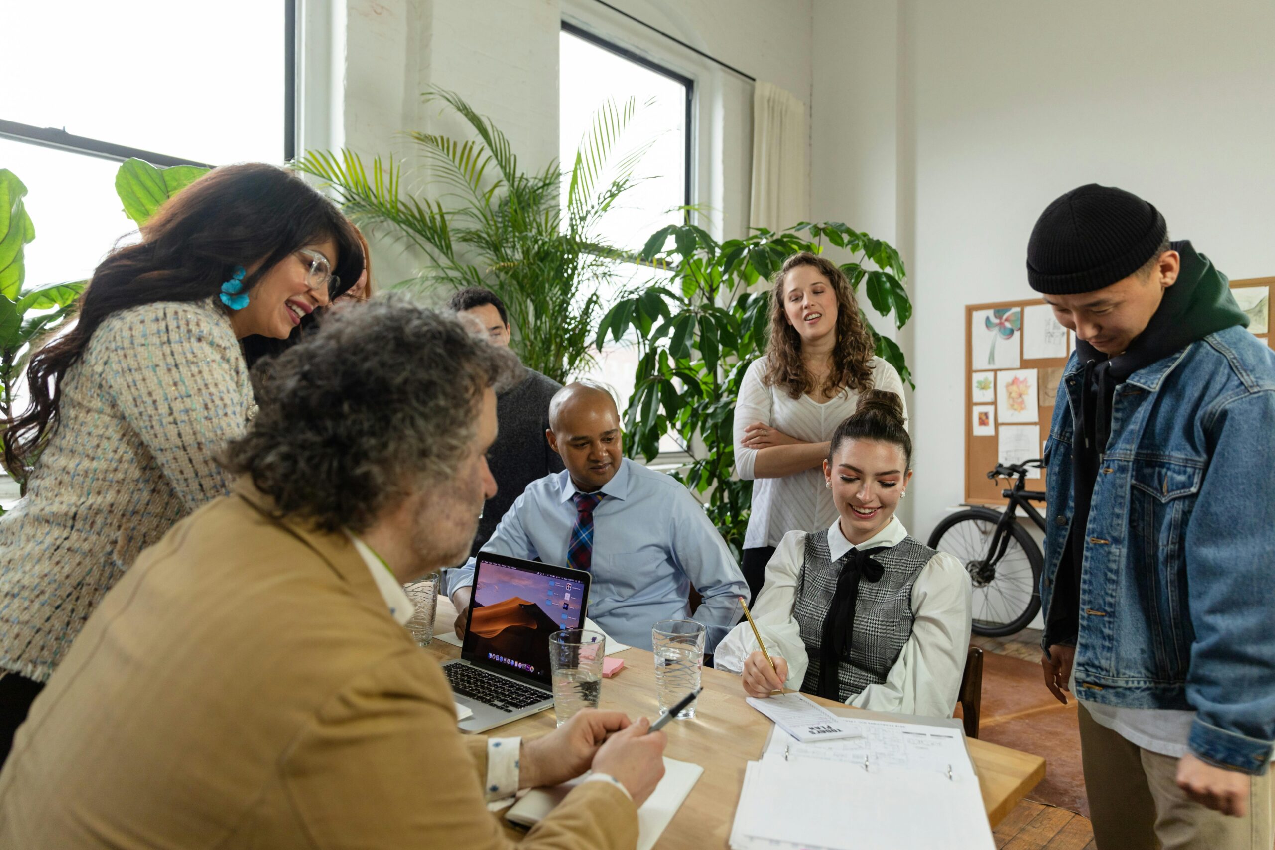 colleagues-looking-at-a-document A team of diverse employees happily collaborating together.