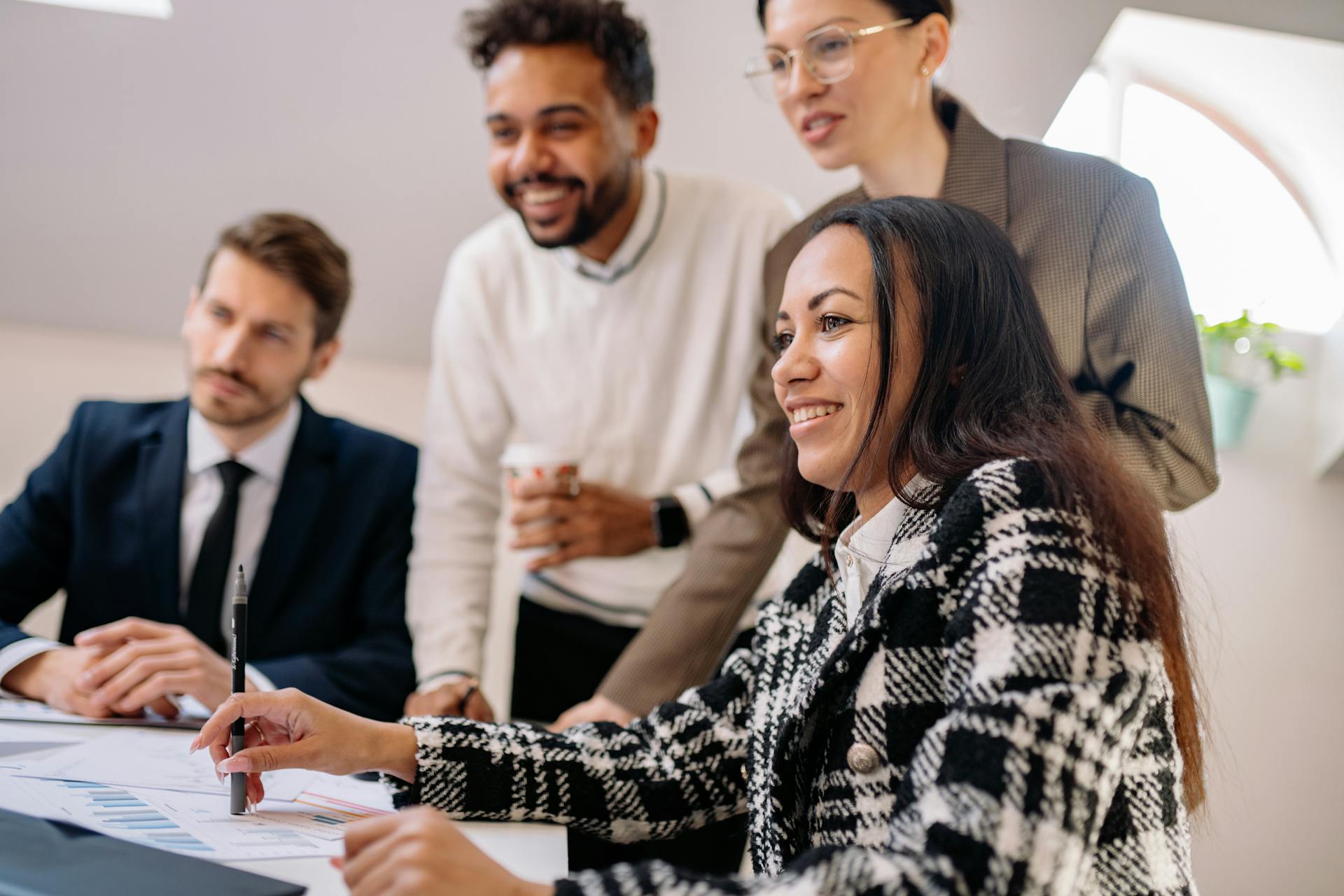 2-male-2-female-looking-at-computer-smiling HR presenting tools and resources to managers for a successful leadership transitions