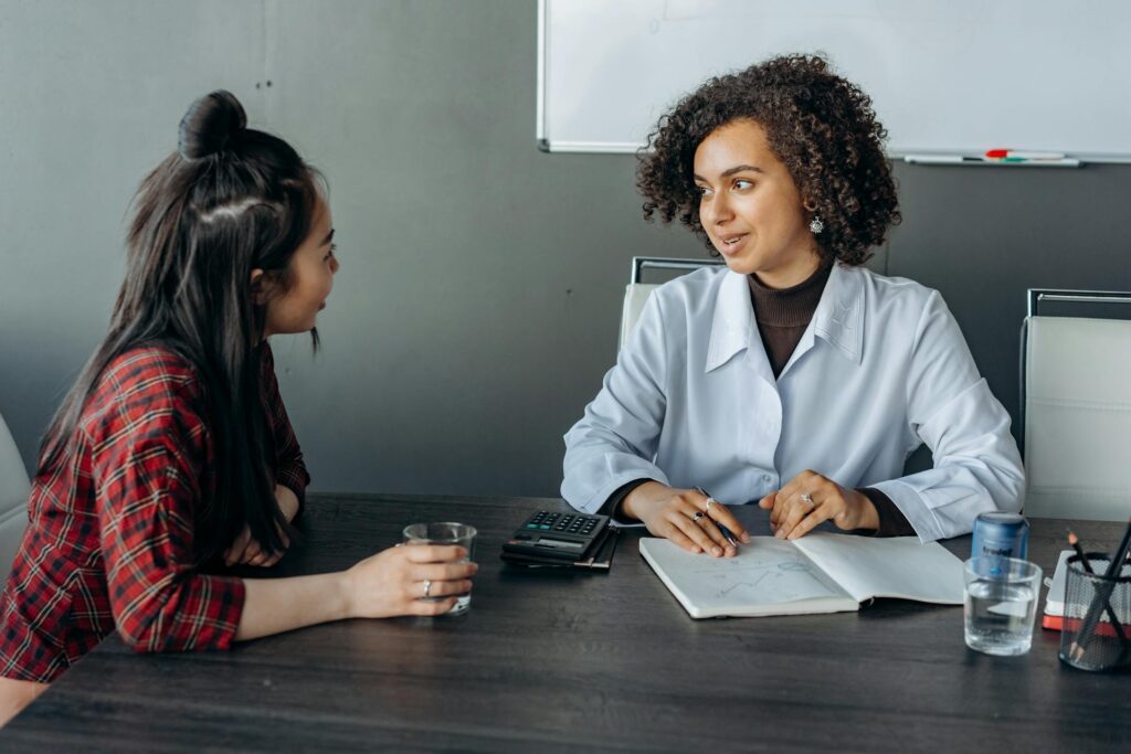 Two women colleagues sharing feedback in conference room