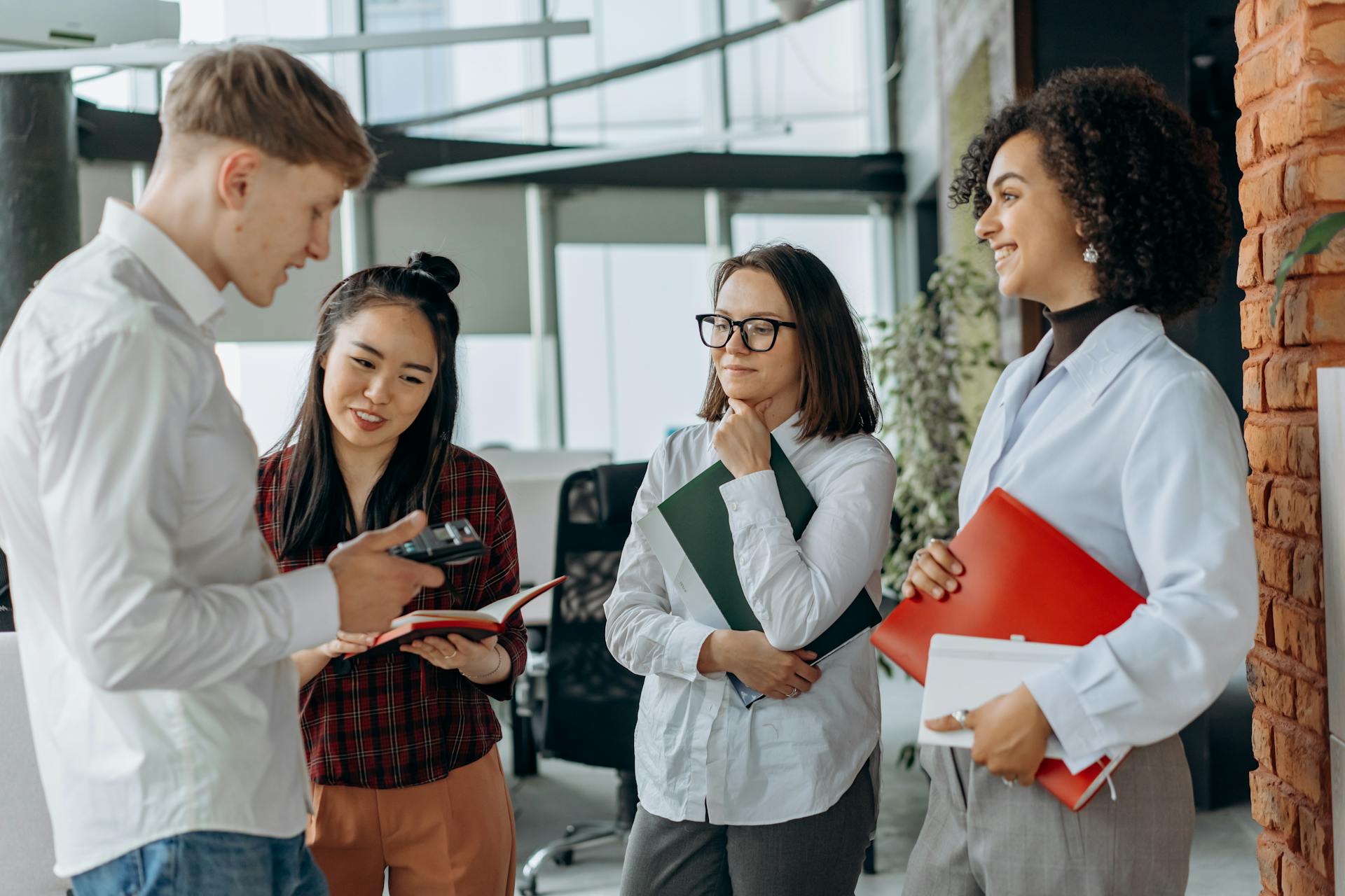 man-and-three-women-talking-numbers HR talking about temporary employee's performance